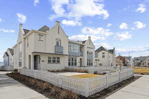 View of front of home featuring stucco siding, a residential view, a fenced front yard, and a chimney
