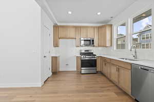Kitchen featuring stainless steel appliances, light wood finished floors, decorative backsplash, recessed lighting, and light stone countertops