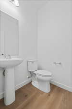 Half bath with toilet and light wood-style flooring