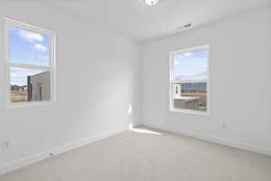 Carpeted spare room with baseboards