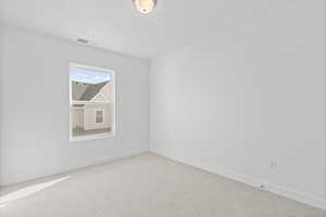 Empty room with baseboards and light colored carpet