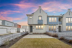 Back of property at dusk featuring stucco siding and board and batten siding