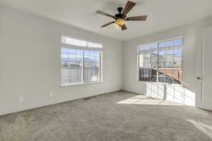 Spare room with carpet floors and a ceiling fan
