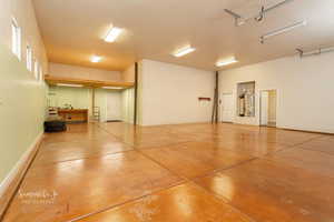 Garage featuring baseboards and water heater