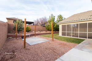 Fenced backyard featuring a patio area and a sunroom