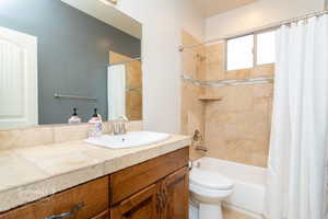 Bathroom featuring vanity and shower / bathtub combination with curtain