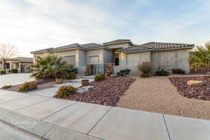 View of front of property with an attached garage, a gate, stucco siding, a tile roof, and driveway