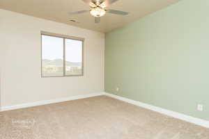 Empty room with carpet and ceiling fan