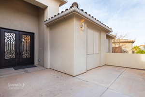 View of exterior entry with stucco siding and french doors