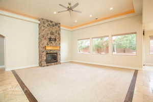 Unfurnished living room featuring a ceiling fan, a stone fireplace, recessed lighting, inlaid floor details, and stone tile flooring
