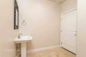 Bathroom featuring stone tile floors and baseboards