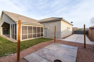Rear view of house with stucco siding, a tile roof, and a fenced backyard