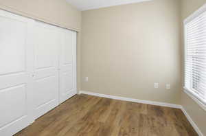 Unfurnished bedroom featuring dark wood-style floors and a closet