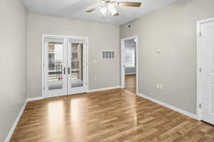 Unfurnished room with french doors, light wood-style floors, and ceiling fan