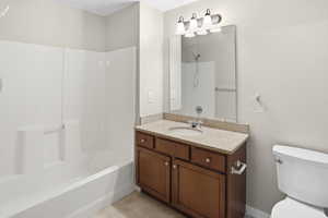 Bathroom featuring vanity,  shower combination, and light tile patterned flooring