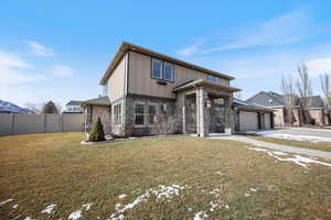 View of front of house with a garage, concrete driveway, stone siding, board and batten siding, and a gate