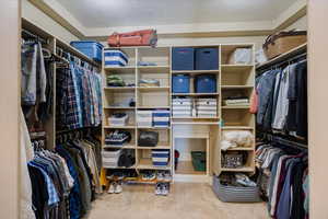 Walk in closet with light colored carpet