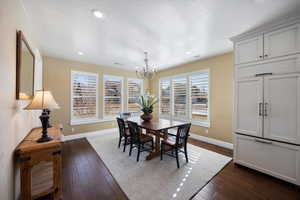 Dining area featuring dark wood-type flooring, hanging lights, and a textured ceiling