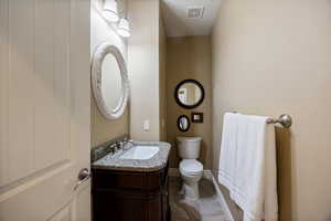 Half bathroom featuring vanity and toilet