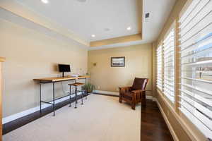 Sitting room featuring recessed lighting, a raised ceiling, dark wood-type flooring, and a desk