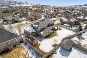 Snowy aerial view featuring a mountain view and a residential view