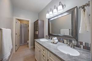 Full bathroom featuring double vanity and a shower with shower curtain