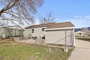 Rear view of property featuring a patio area, a mountain view, and a shingled roof