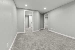 Below grade area featuring light colored carpet and recessed lighting