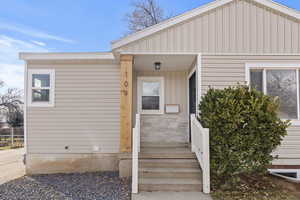 Doorway to property featuring covered porch and board and batten siding