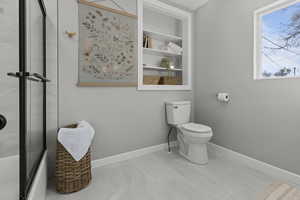 Full bathroom with toilet and baseboards