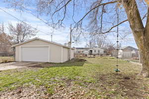 View of yard featuring a garage, an outbuilding, and a residential view