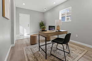 Office area with recessed lighting and light wood-style floors