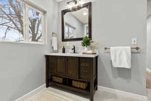 Bathroom featuring vanity, decorative backsplash, and light tile patterned flooring