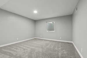 Spare room featuring light carpet and baseboards