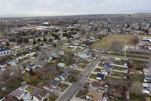 Aerial view of property and surrounding area featuring nearby suburban area