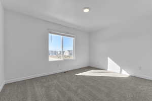 Carpeted spare room with baseboards