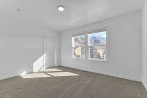 Spare room featuring baseboards and light carpet