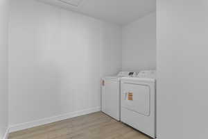 Laundry room with light wood-type flooring and independent washer and dryer