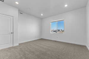 Empty room featuring carpet floors and recessed lighting