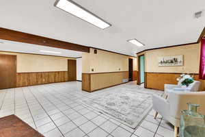 Reception with wainscoting, wooden walls, crown molding, and beamed ceiling