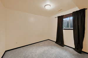 Unfurnished room featuring light carpet and baseboards