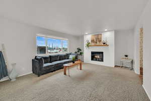 Living room with light colored carpet, a fireplace, and recessed lighting