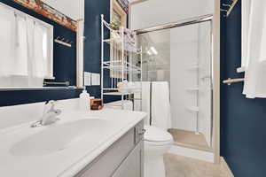 Bathroom with vanity, a stall shower, and light tile patterned flooring