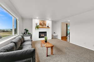 Living room featuring a large fireplace, recessed lighting, and carpet floors