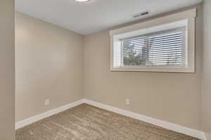 Unfurnished room with baseboards and light colored carpet