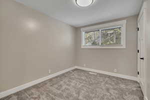Empty room featuring light carpet and baseboards