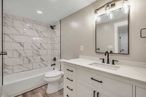 Bathroom with vanity, bathing tub / shower combination, and light wood-type flooring