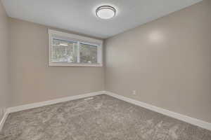 Empty room featuring carpet floors and baseboards