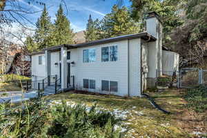View of front facade with a gate, brick siding, and a chimney