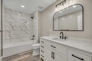 Bathroom featuring bathing tub / shower combination, vanity, light wood-style flooring, and recessed lighting